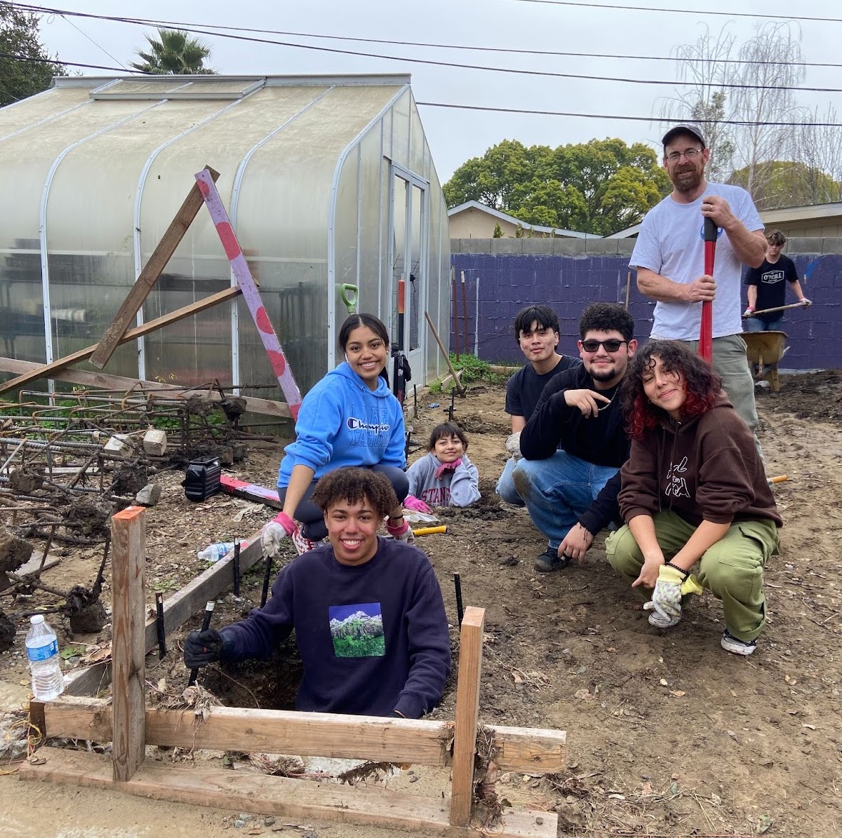 Students smiling while constructing a garden